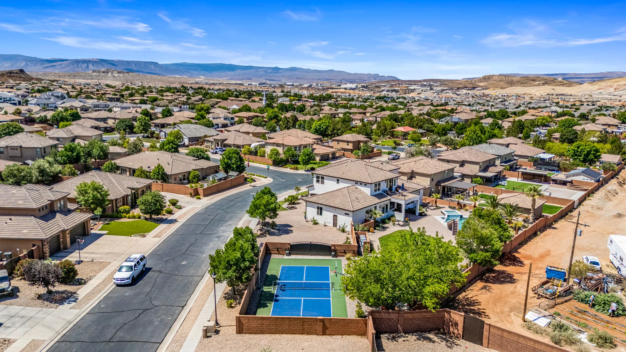 Residential neighborhood with a private outdoor sport court, mature green trees, and an array of single-story homes
