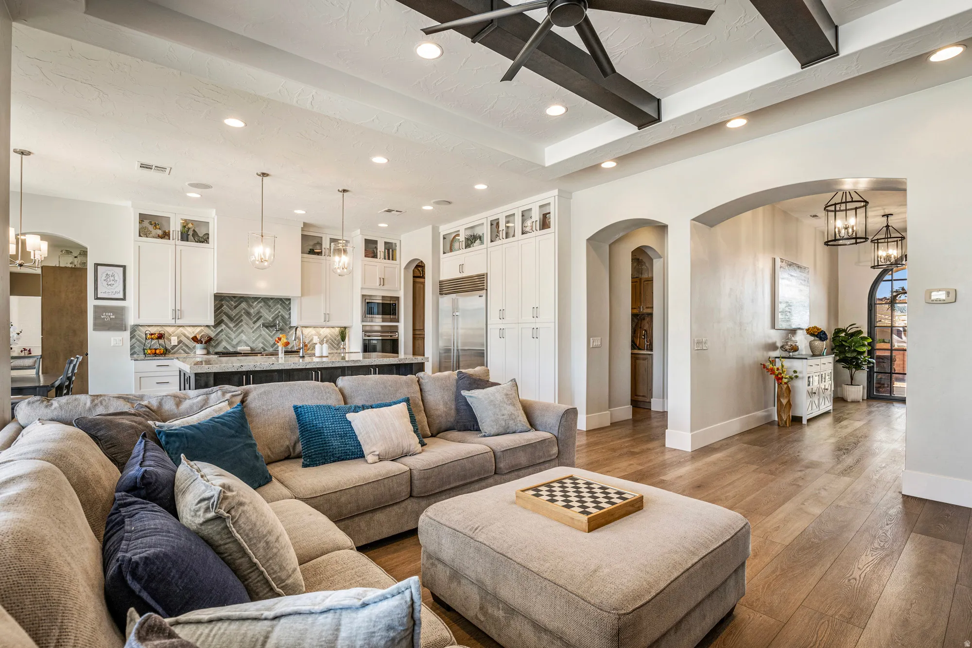 Open-concept living area with wood-finish flooring, a contemporary ceiling fan, and recessed lighting