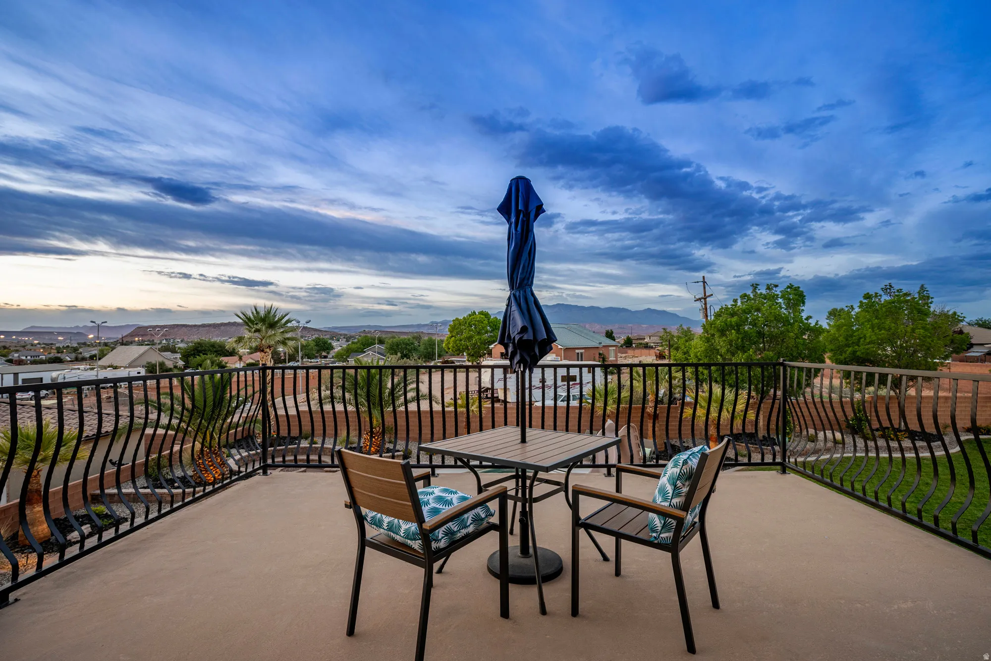 Rooftop patio with decorative wrought iron railing and expansive regional landscape
