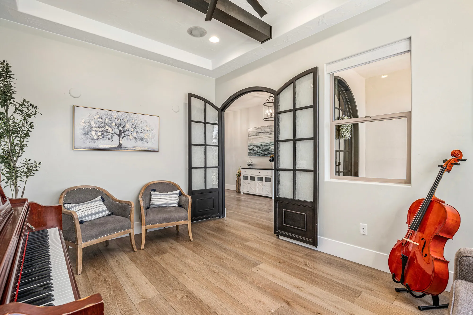 Room featuring wood-finish flooring, a tray ceiling with recessed lighting, and exposed ceiling beams