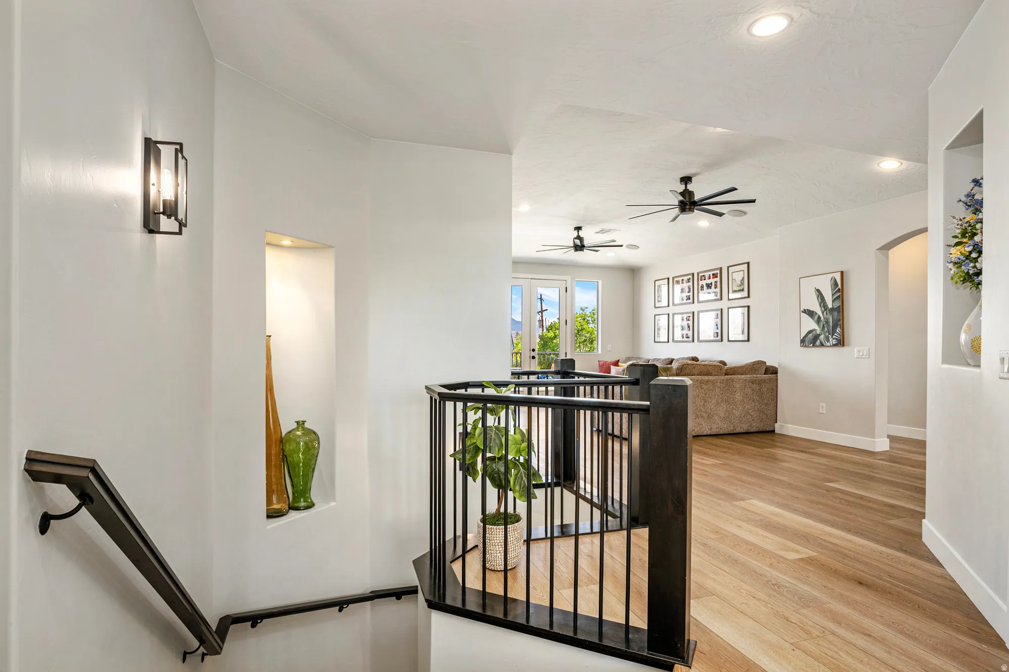Upper-level landing featuring wood-finish flooring and a black metal railing