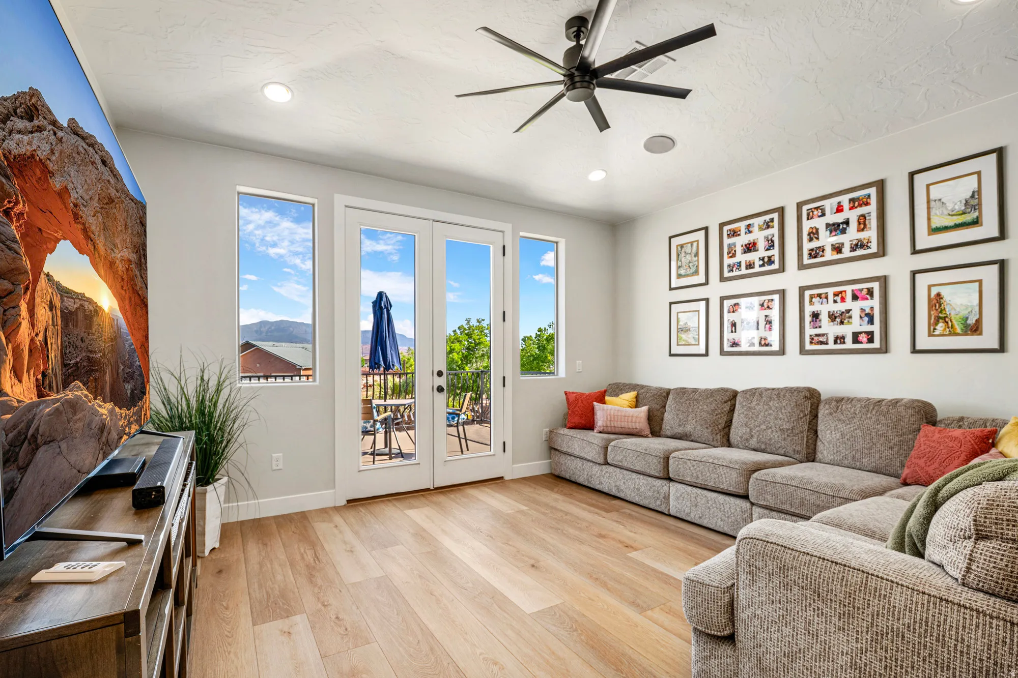Spacious interior room featuring wood-finish flooring, recessed lighting, and a modern ceiling fan