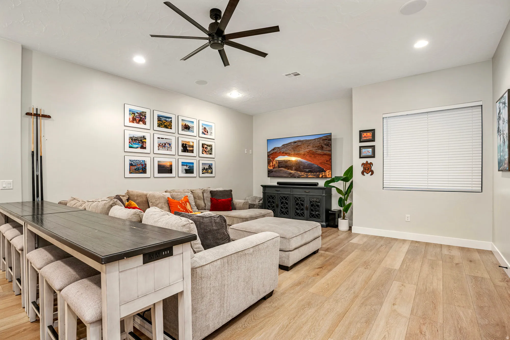 Open living area featuring wood-finish flooring, recessed lighting, and a contemporary ceiling fan