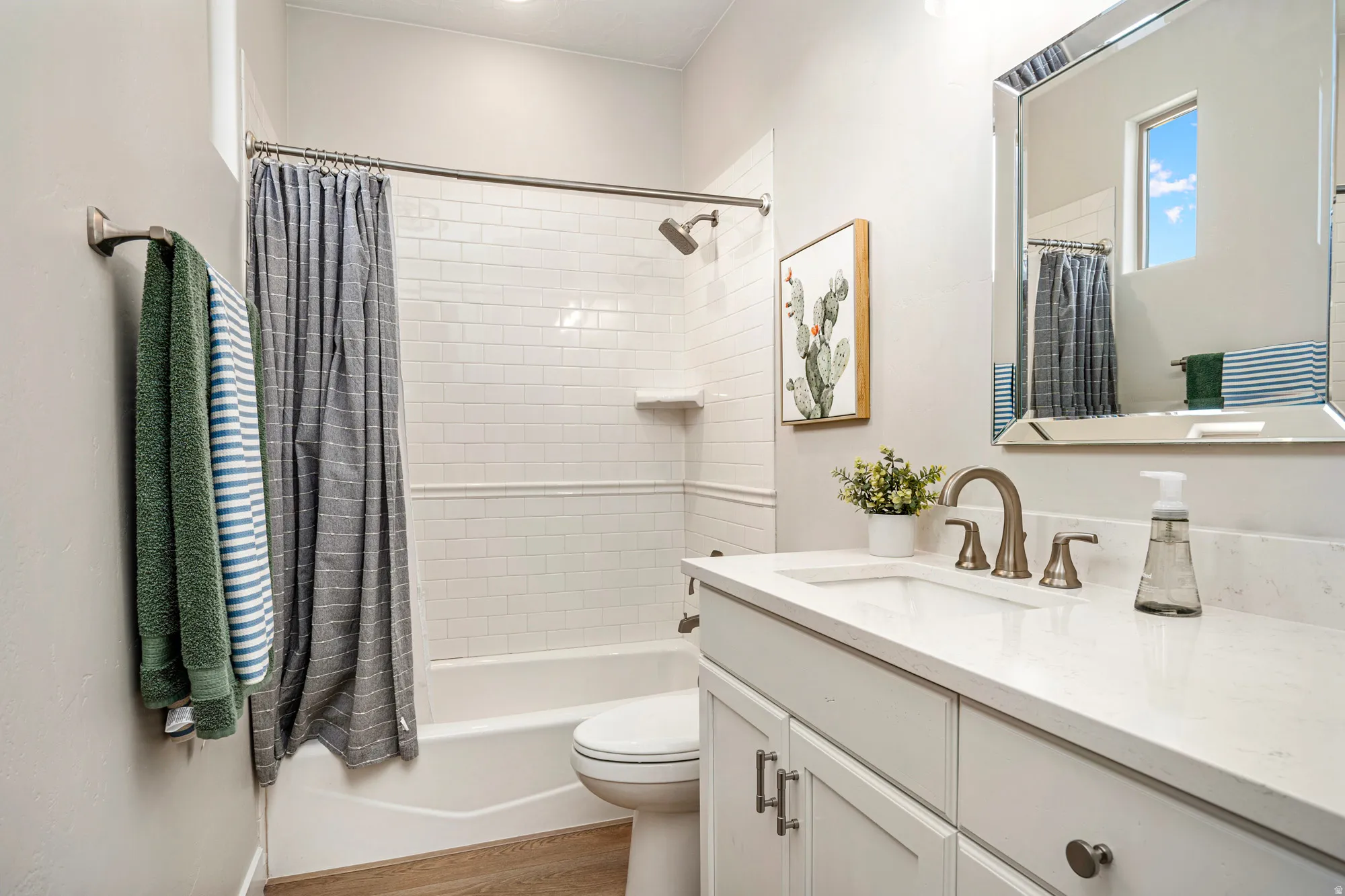 Bathroom featuring a single vanity with stone-finish countertop, undermount sink, and brushed nickel faucet