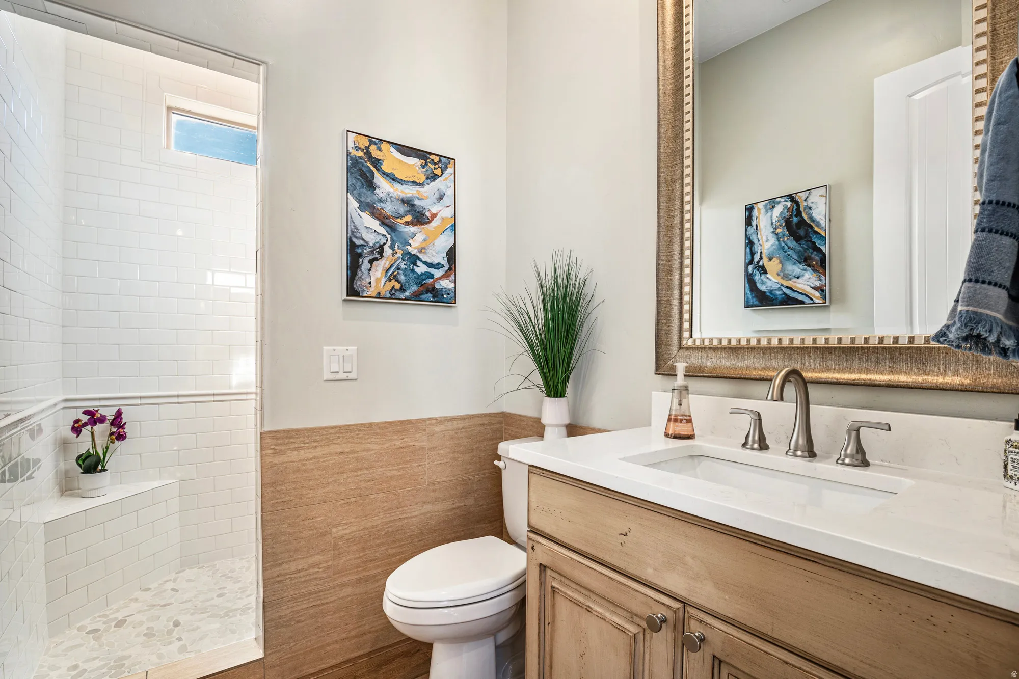 Contemporary bathroom featuring a walk-in shower with subway tile and pebble flooring