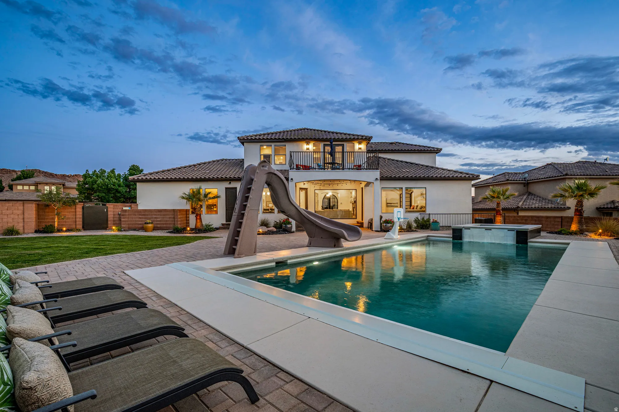 Expansive backyard oasis featuring a large swimming pool with integrated spa and waterfall feature