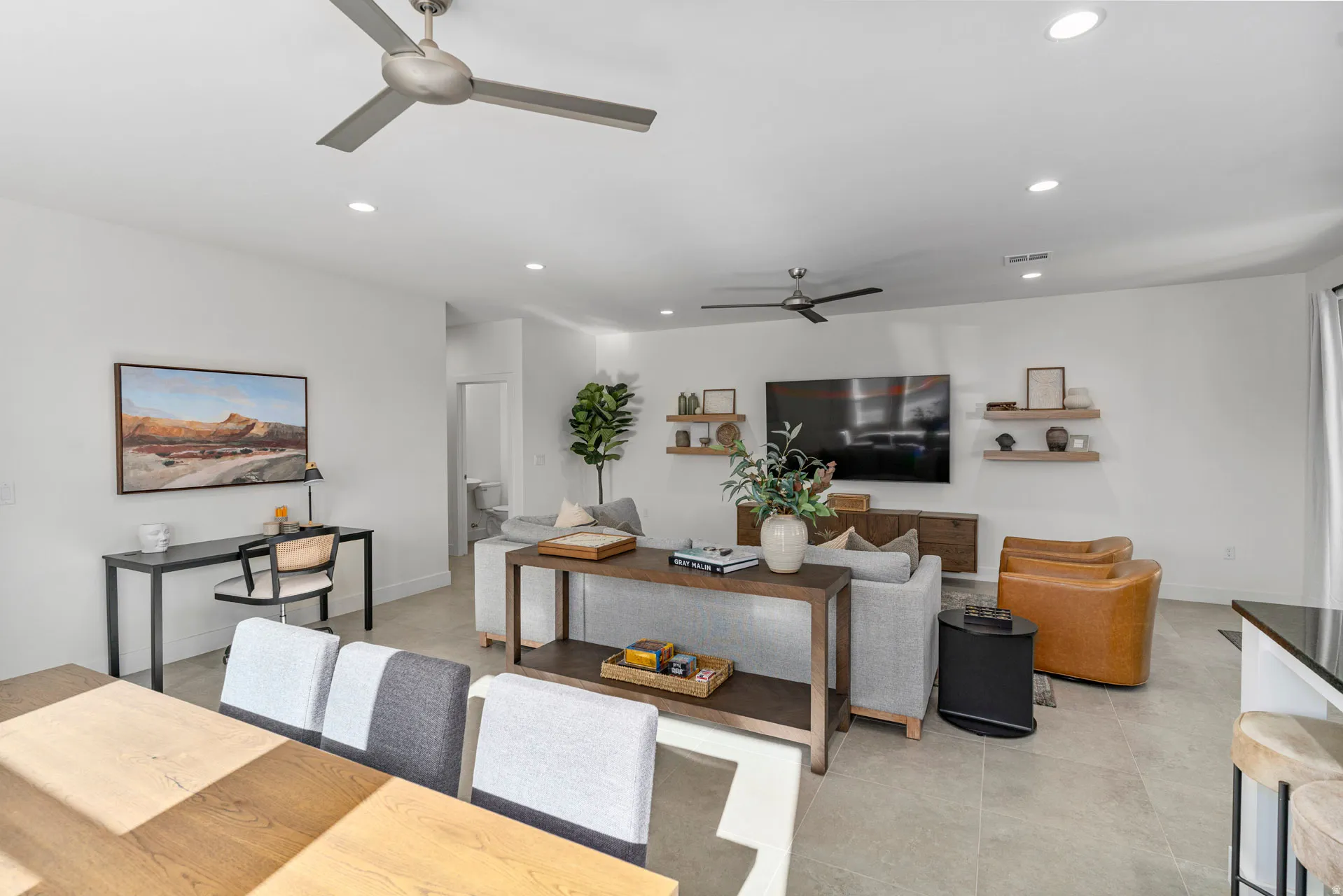 Open-concept living space featuring light-toned tile flooring and recessed lighting