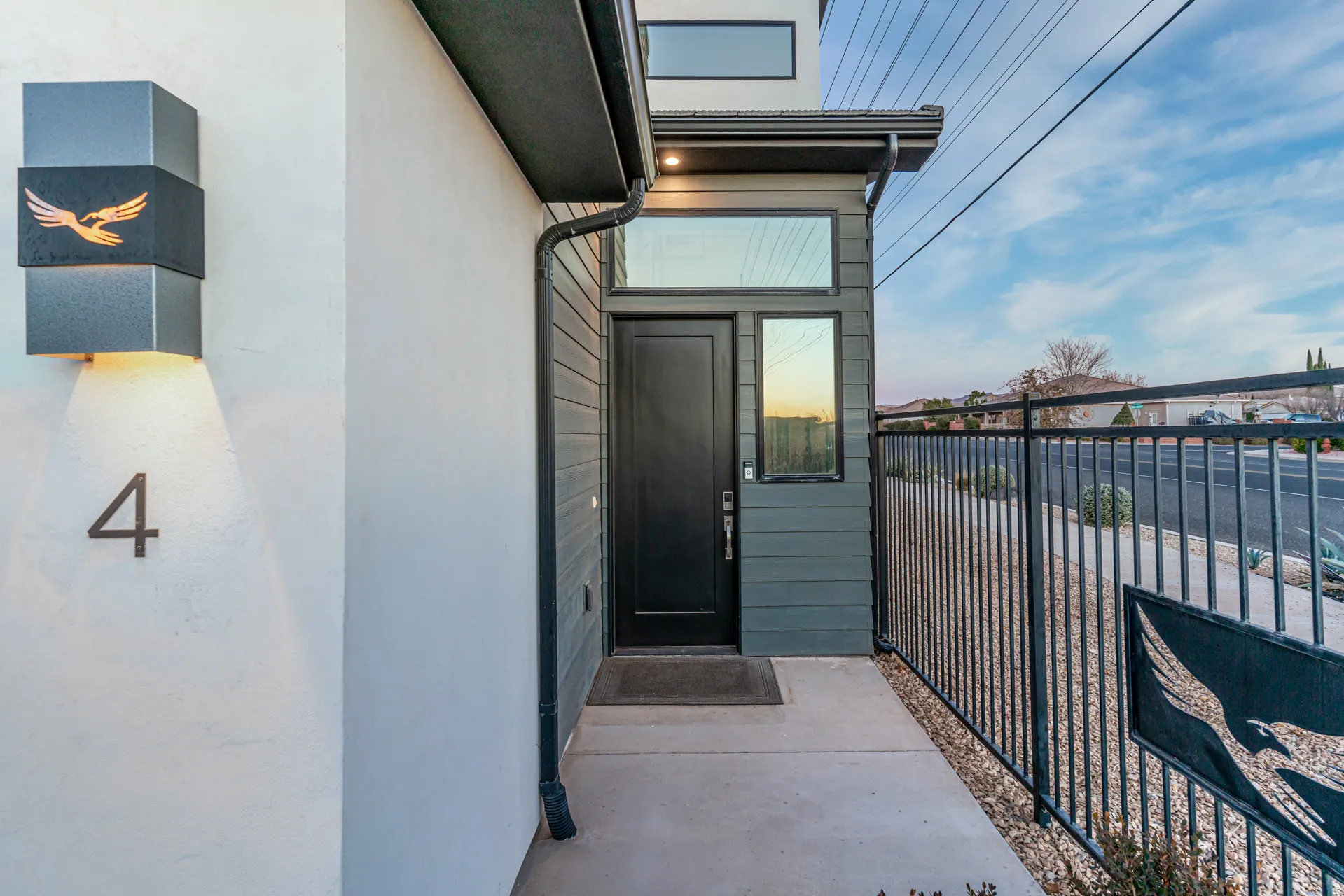 Modern exterior featuring a dark entry door, horizontal siding, and a decorative wall sconce