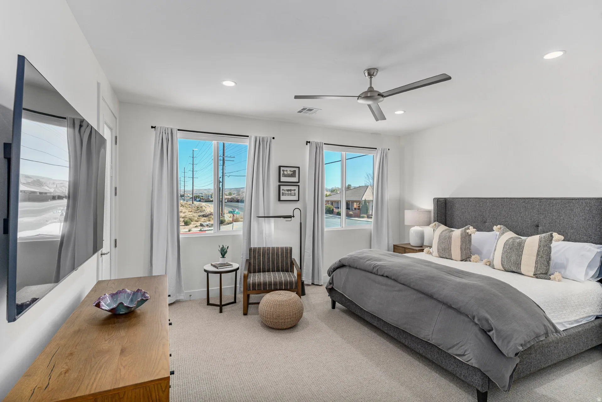 Primary carpeted room featuring dual windows, a ceiling fan, recessed lighting, and a wood-finish dresser