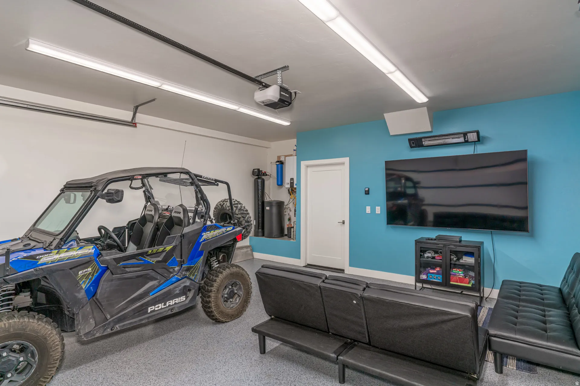 Finished garage space featuring an epoxy floor, track lighting, and a painted accent wall