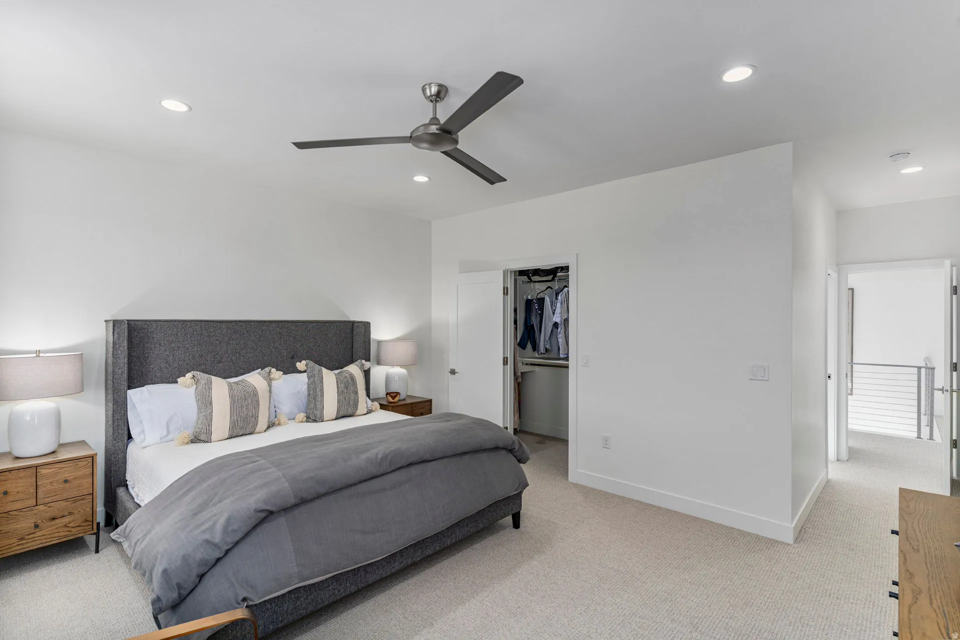 Primary bedroom with upgraded carpet featuring a ceiling fan, recessed lighting, and a built-in closet with shelving and hanging space