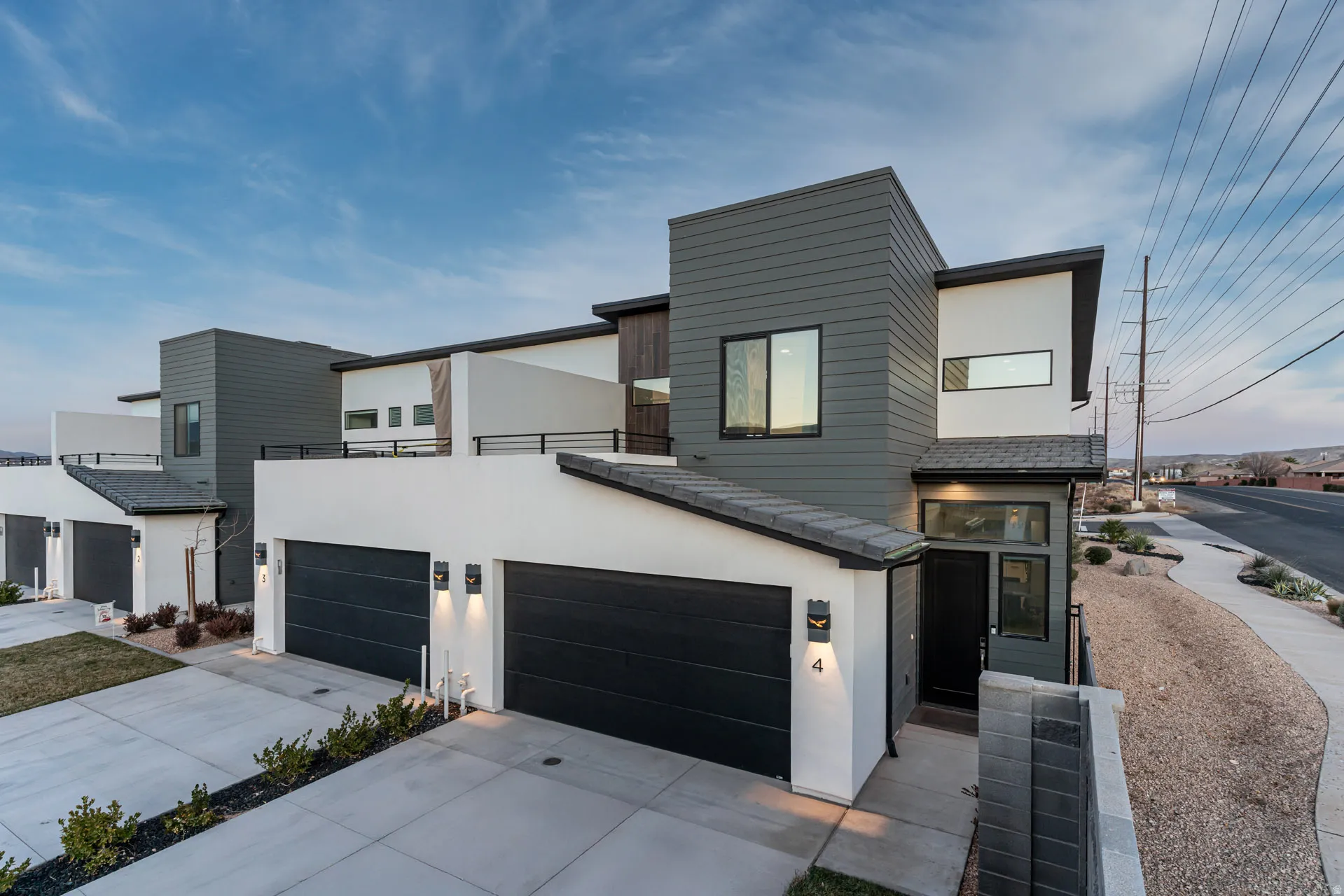 Contemporary multi-story residence featuring a white stucco and dark gray siding exterior
