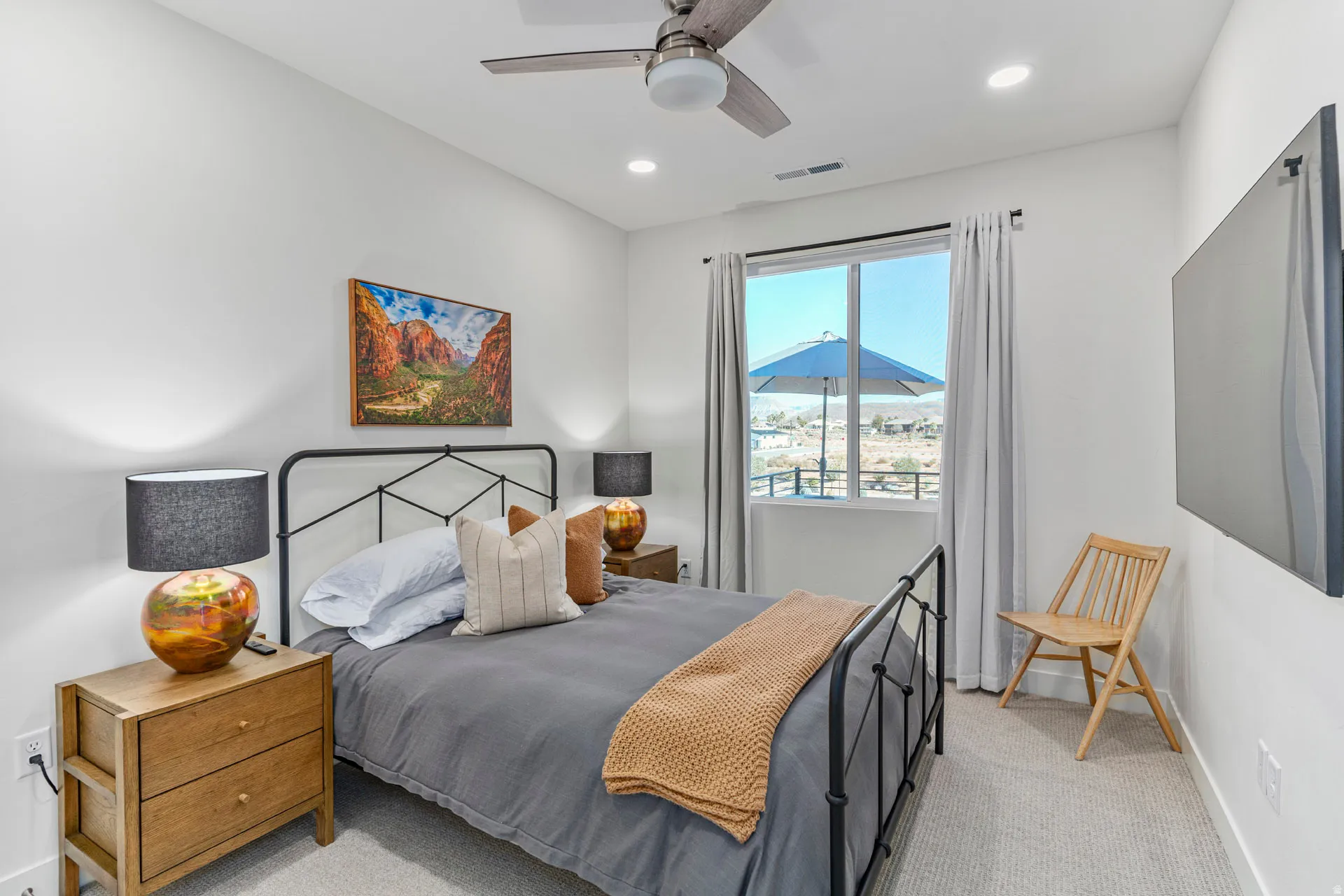 Second carpeted bedroom featuring a ceiling fan with integrated lighting, recessed ceiling lights, a wall-mounted television, and a window with curtains