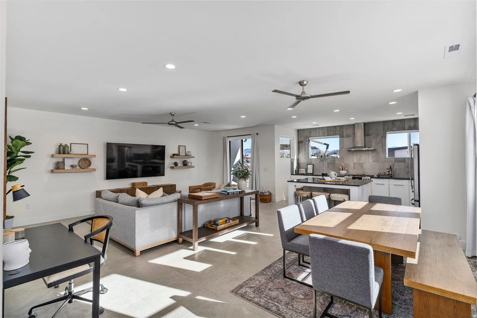 Open-concept living space featuring neutral tile flooring and recessed lighting throughout