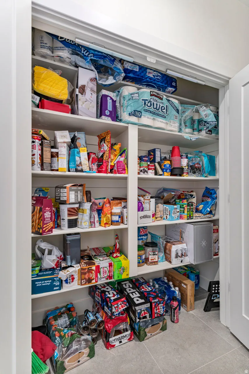 Built-in pantry shelving featuring multiple tiers and a durable tile flooring