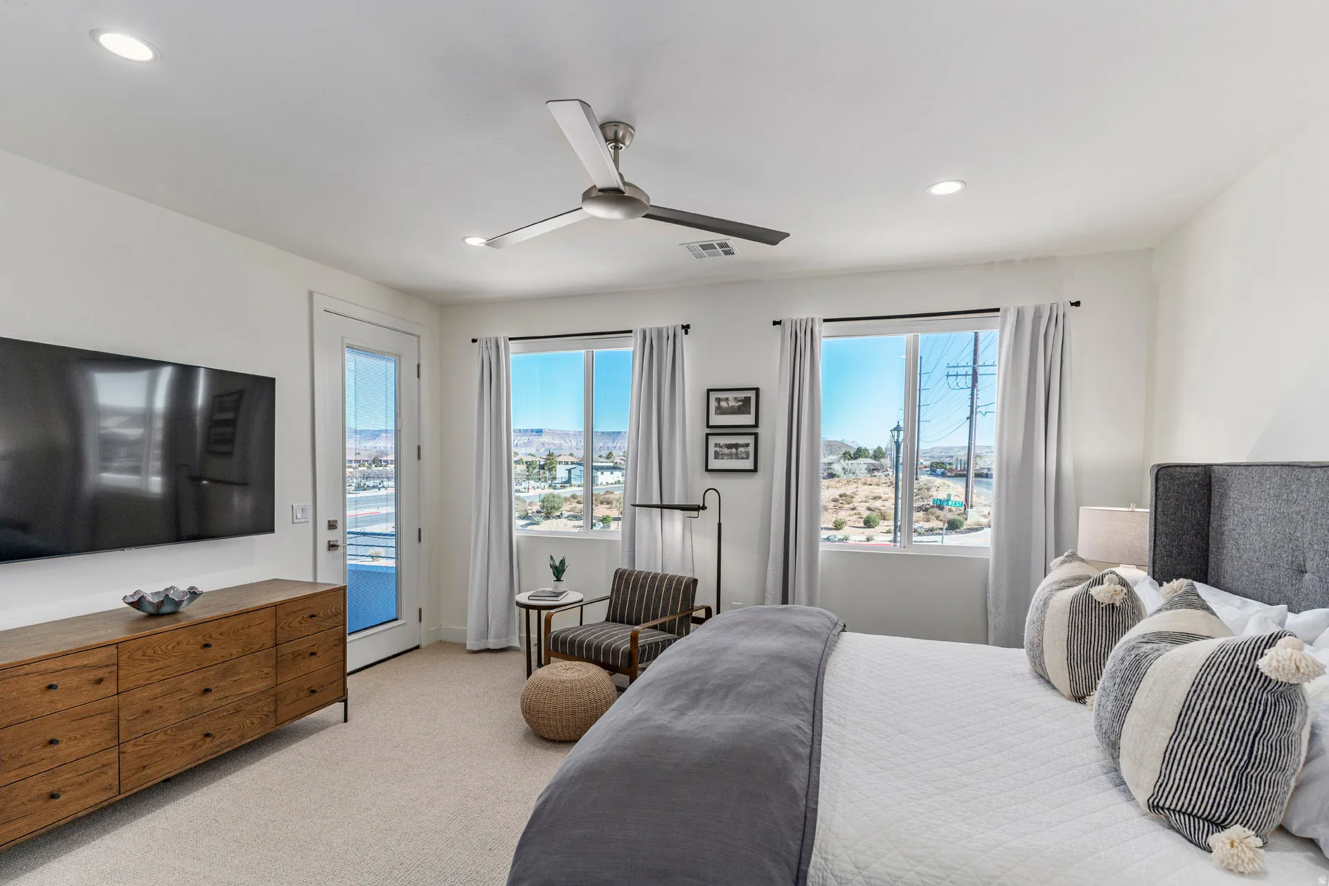 Primary bedroom with white walls with recessed lighting and a ceiling fan