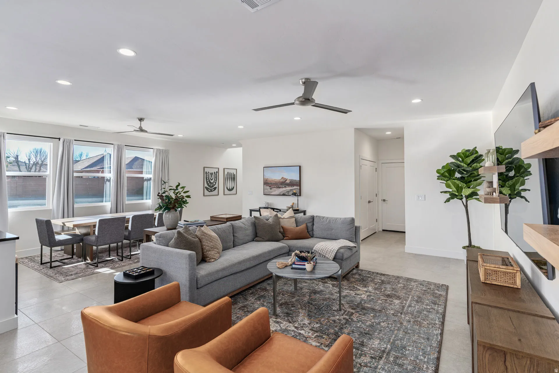 Open-concept living area featuring light-toned tile flooring and recessed lighting