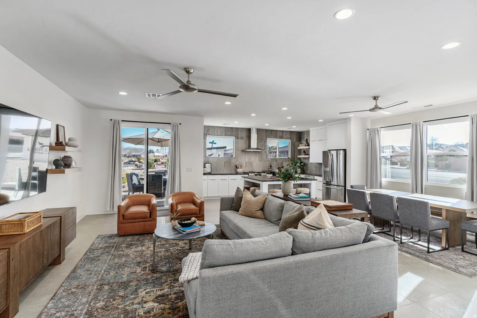 Open-concept living space featuring a sliding glass door to the exterior, recessed lighting, and multiple ceiling fans