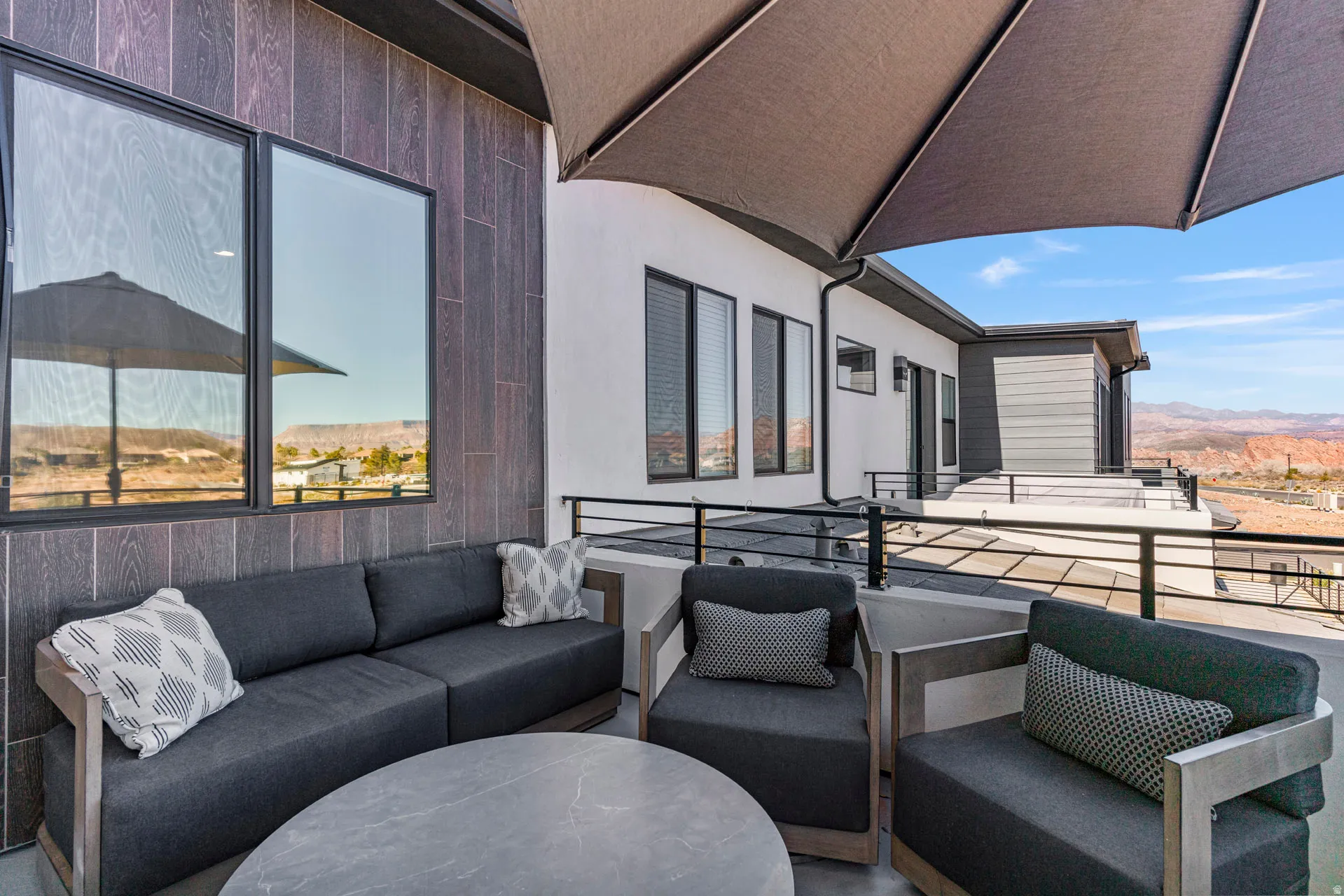 Primary bedroom outdoor patio featuring dark wood-look wall paneling and a light-colored exterior finish