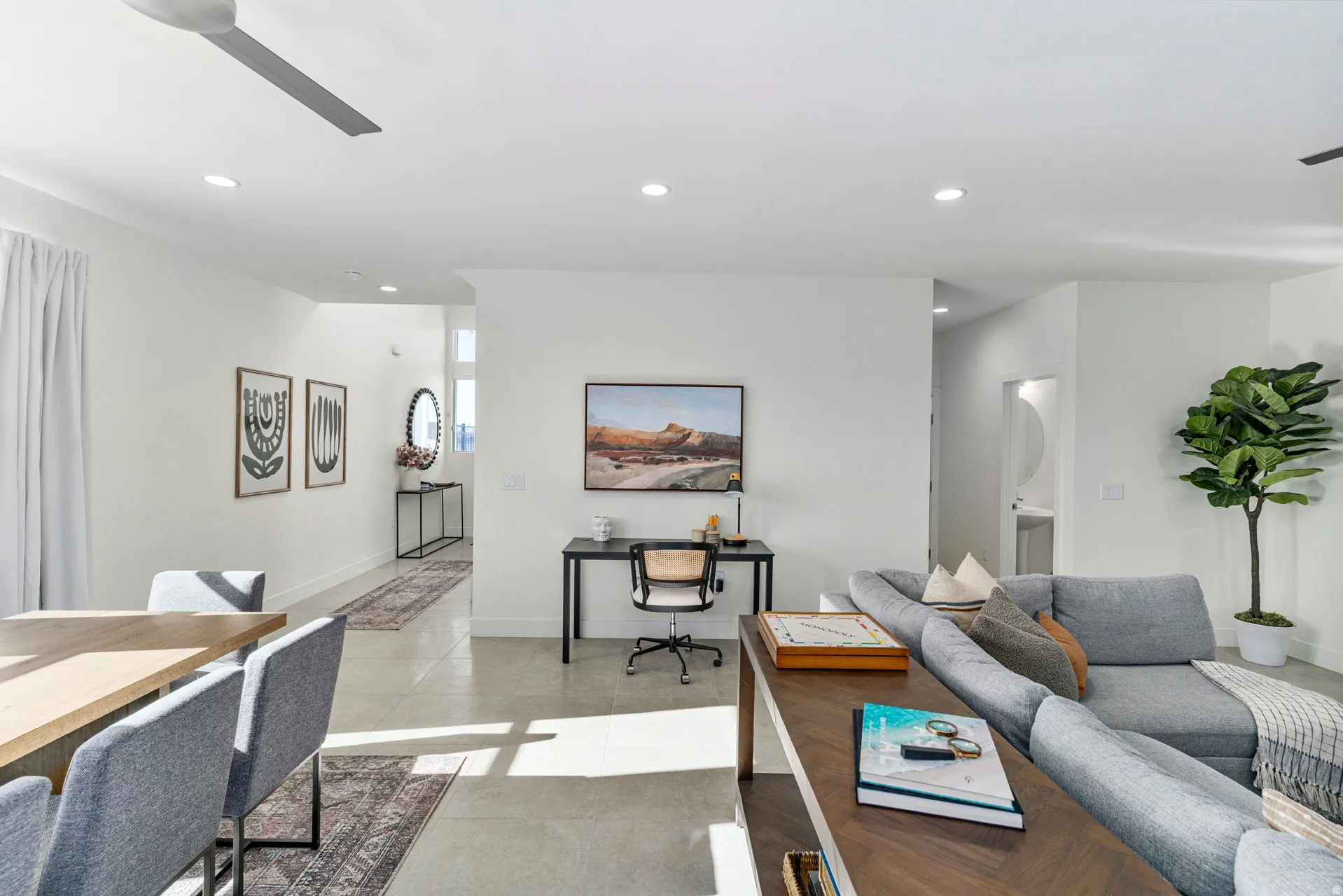 Open-concept living area featuring light-toned flooring, recessed lighting, a ceiling fan, and white walls