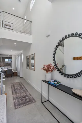Entryway featuring a two-story ceiling, a second-story landing with cable railing, and high windows providing natural light