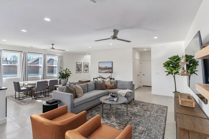 Open-concept living area featuring light-toned tile flooring and recessed lighting
