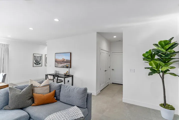 Open-concept living space featuring recessed lighting, light-toned tile flooring, and white baseboards