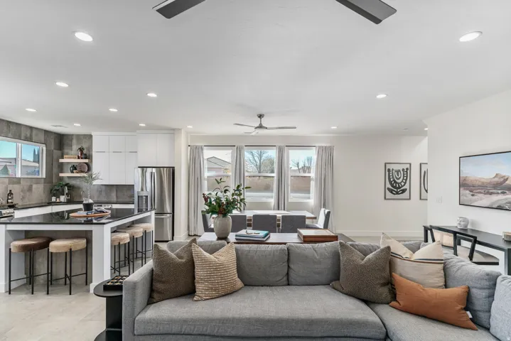 Open-concept living space featuring a spacious kitchen island with seating, stainless steel appliances, recessed lighting, and multiple windows