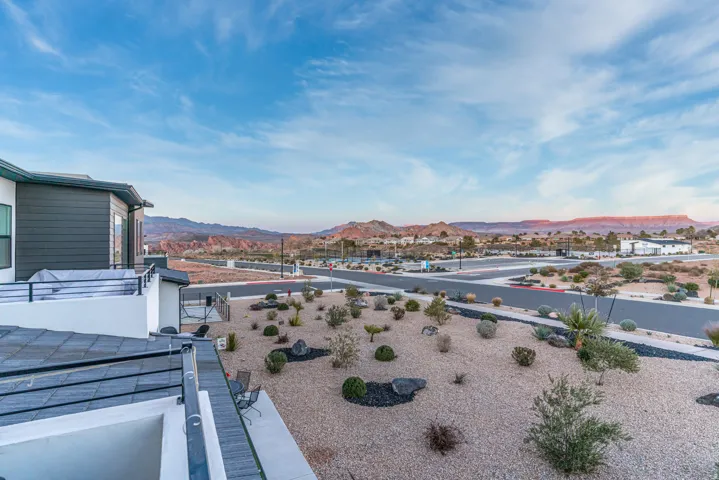 Rooftop deck off primary bedroom featuring metal railings, and desert landscaping