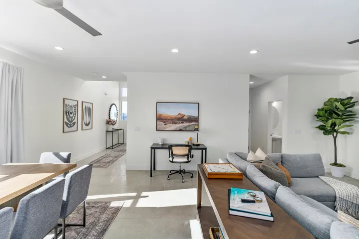 Open-concept living area featuring light-toned flooring, recessed lighting, a ceiling fan, and white walls