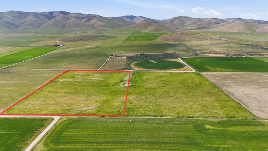Expansive land parcel outlined in red, featuring open fields and distant mountain ranges