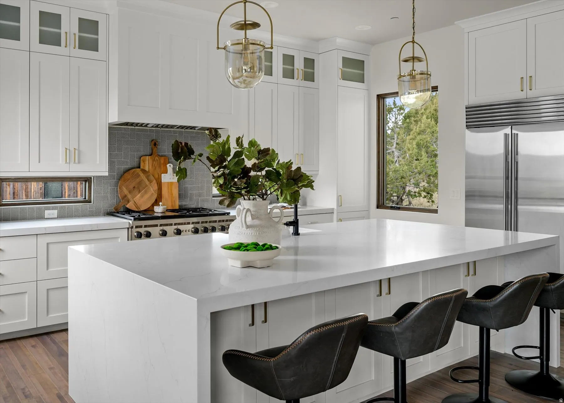 Kitchen featuring a large waterfall island, stainless steel appliances, and a tile backsplash