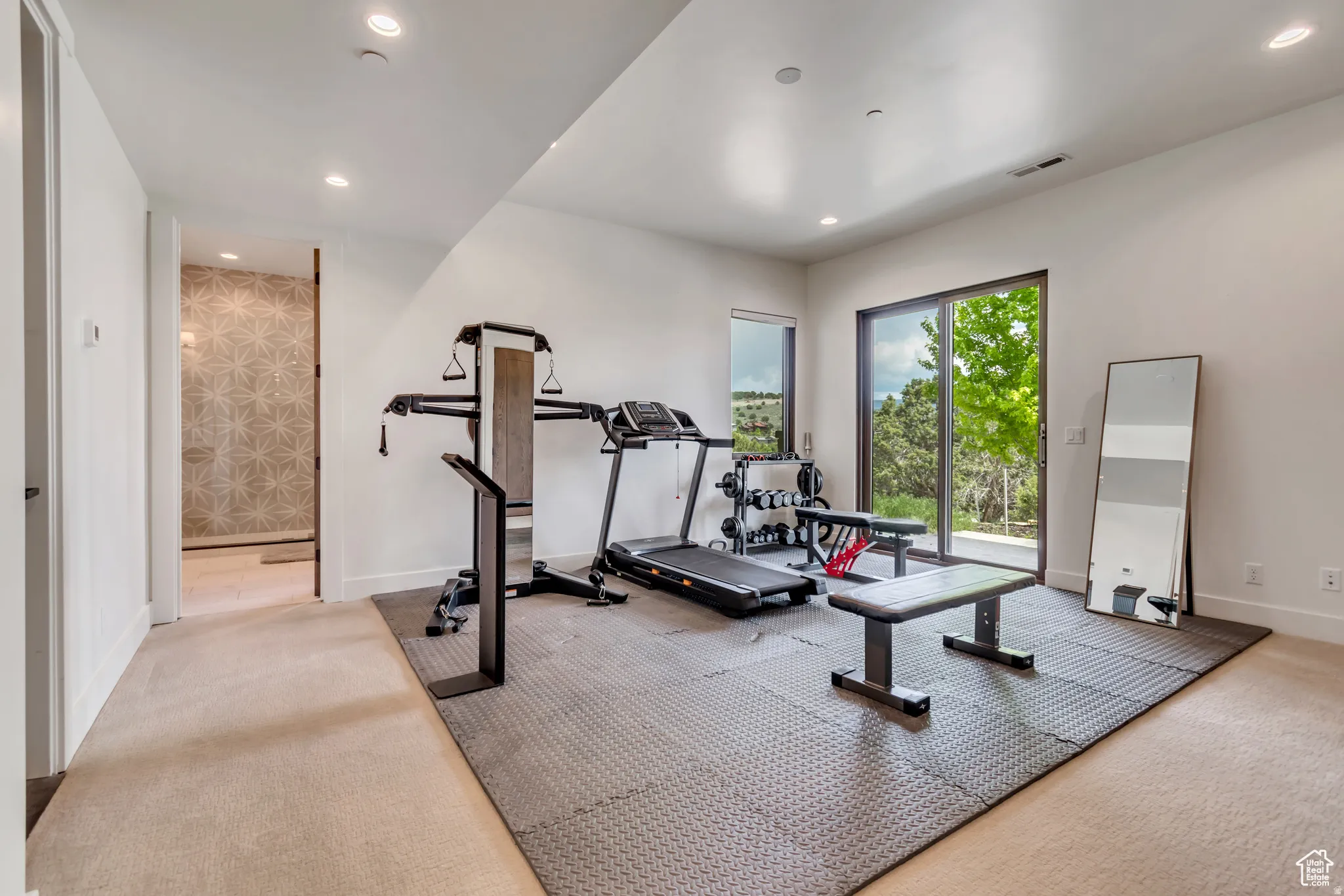 Spacious room featuring a sliding glass door providing outdoor access, recessed lighting, and a large window