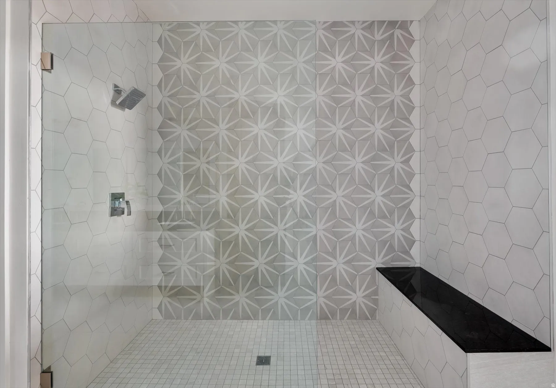 Walk-in shower featuring  custom tile, and a rainfall showerhead.