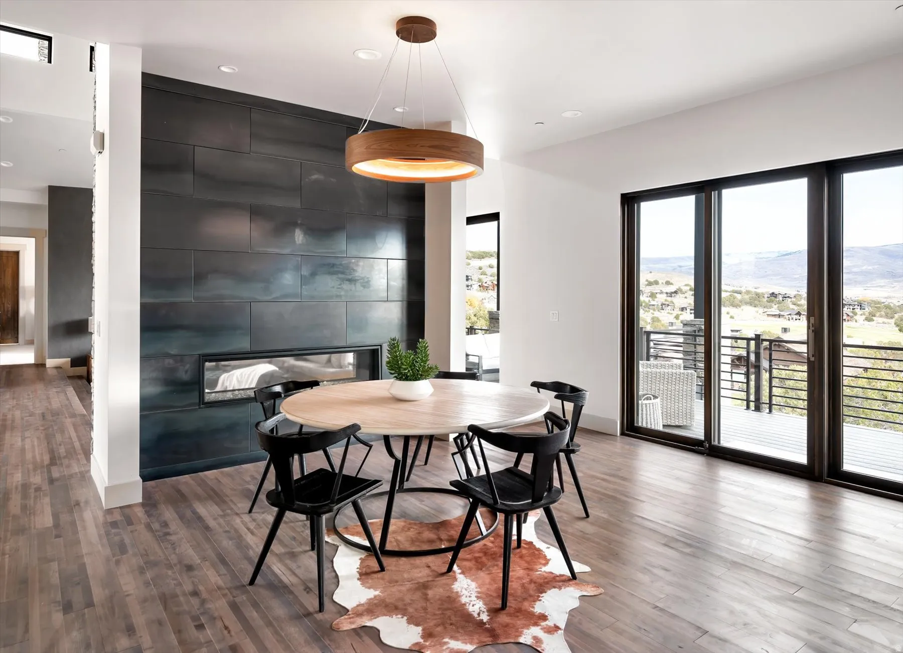 Dining area featuring a linear fireplace with metal panel surround