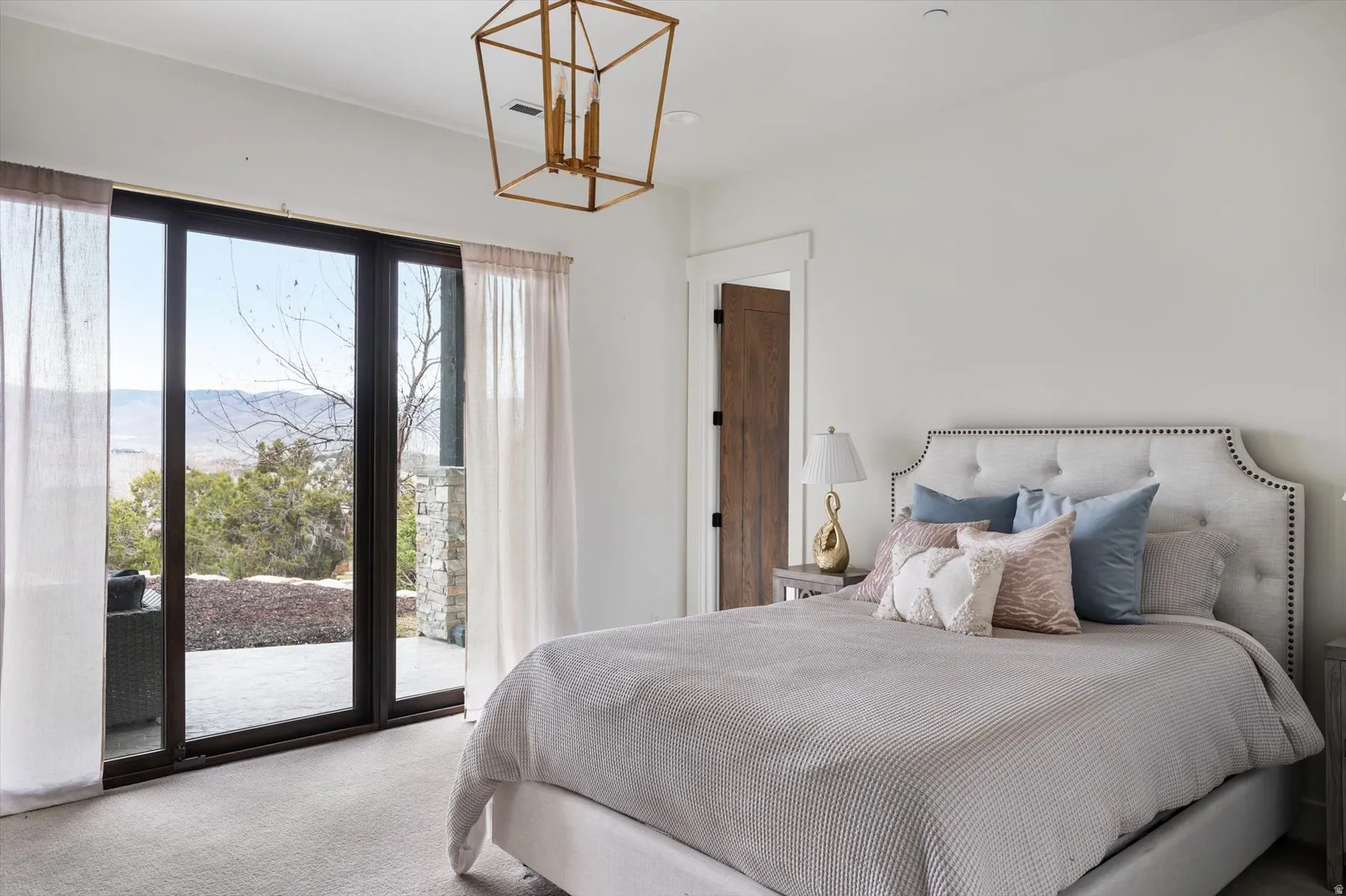 Bedroom featuring and en-suite bath and sliding glass doors opening to an back patio.