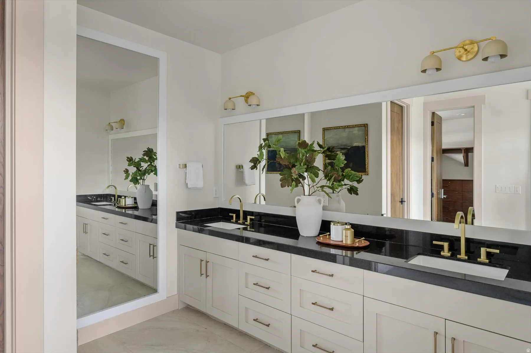 Master bathroom featuring oversized dual vanity with stone countertops.
