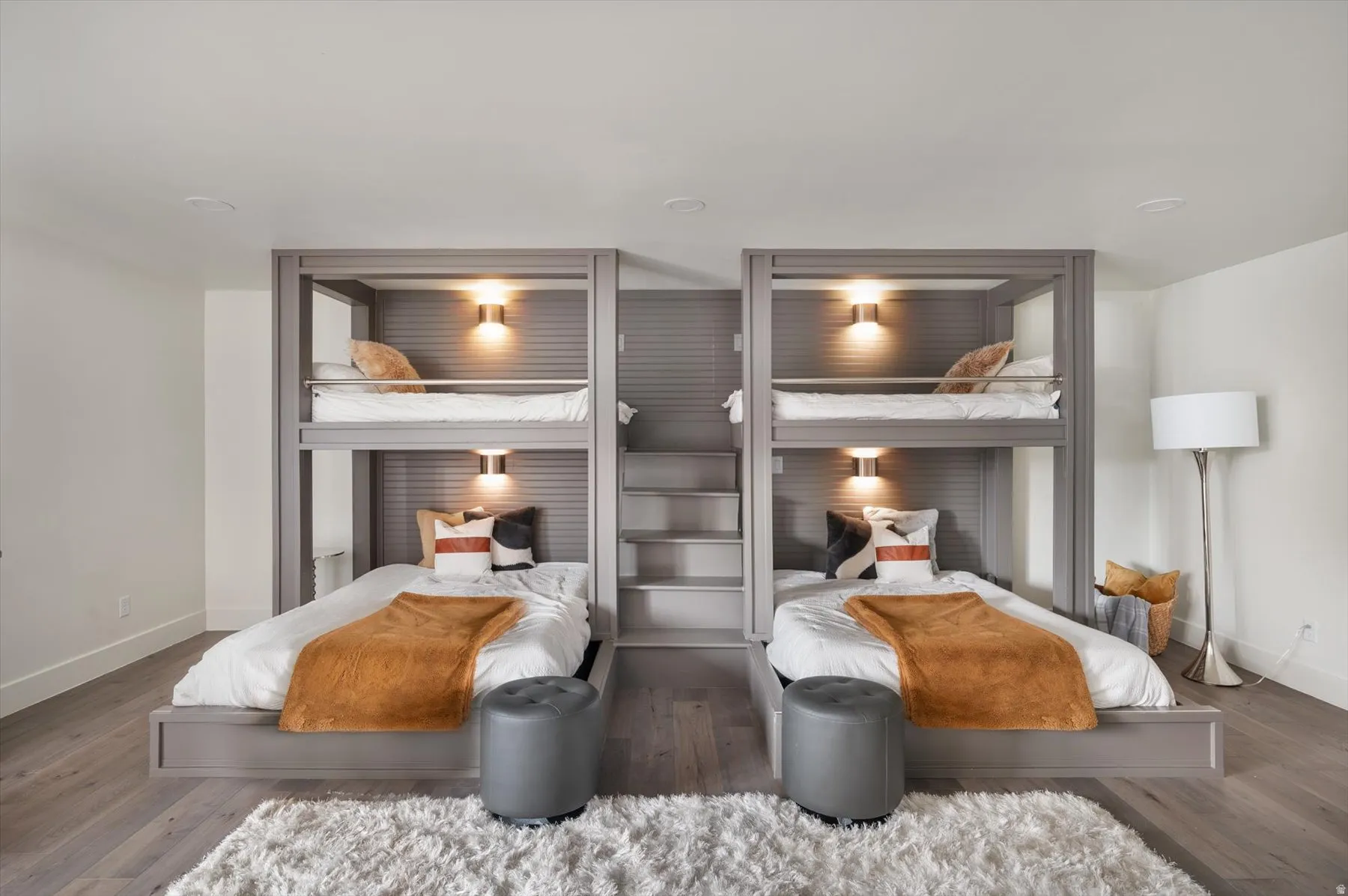 Built-in bunk beds with integrated lighting, wood-finish flooring, recessed ceiling lights,