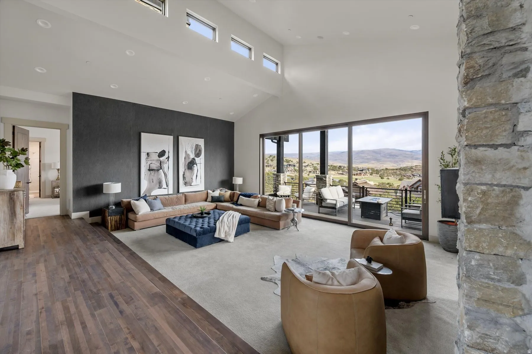 Spacious living area featuring high vaulted ceiling, and double sided floor to ceiling fireplace.