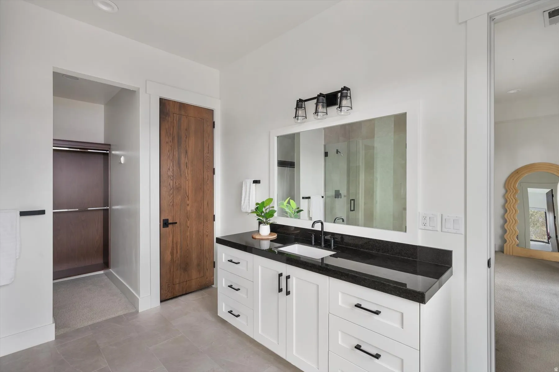 En-Suite Bathroom featuring walk in closet with walnut finish built ins