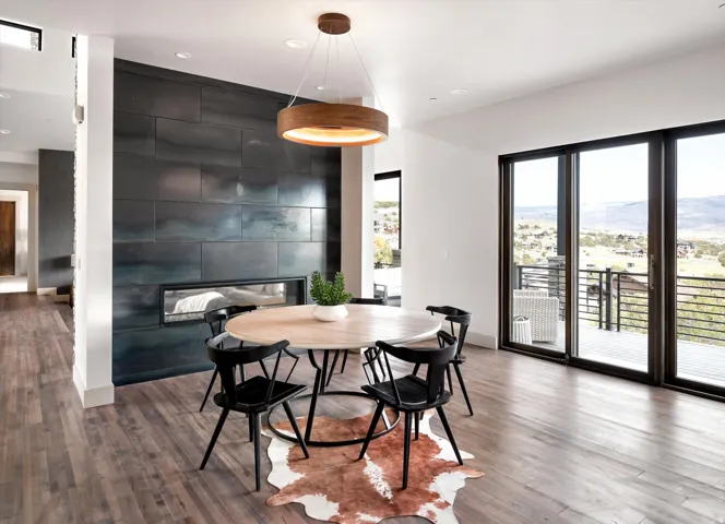 Dining area featuring a linear fireplace with metal panel surround