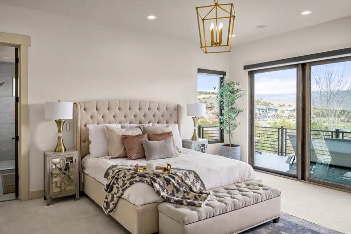 Spacious master bedroom featuring large sliding glass doors, and automatic shades.
