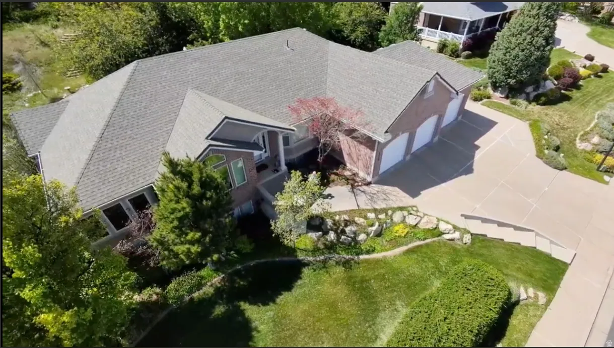 Spacious residence featuring a three-car garage, brick exterior, and a multi-level roofline