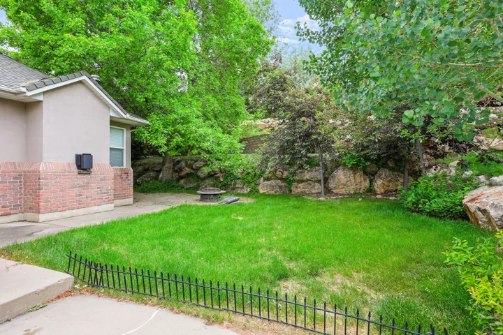 Expansive green lawn bordered by a low black metal fence