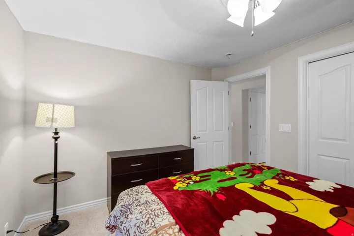 Carpeted room with neutral wall tones, a ceiling-mounted light fixture, and white interior doors