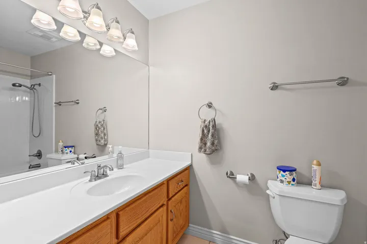 Full-length mirror over a white countertop with an integrated sink and chrome faucet