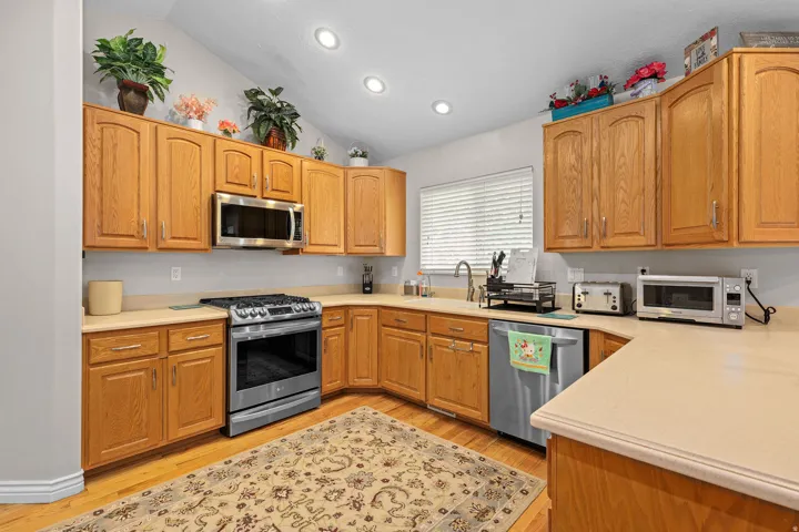 Kitchen featuring wood-finish flooring, recessed lighting, and a vaulted ceiling