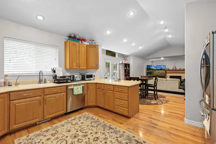 Kitchen featuring wood-finish cabinetry, stainless steel dishwasher, and a window above the sink