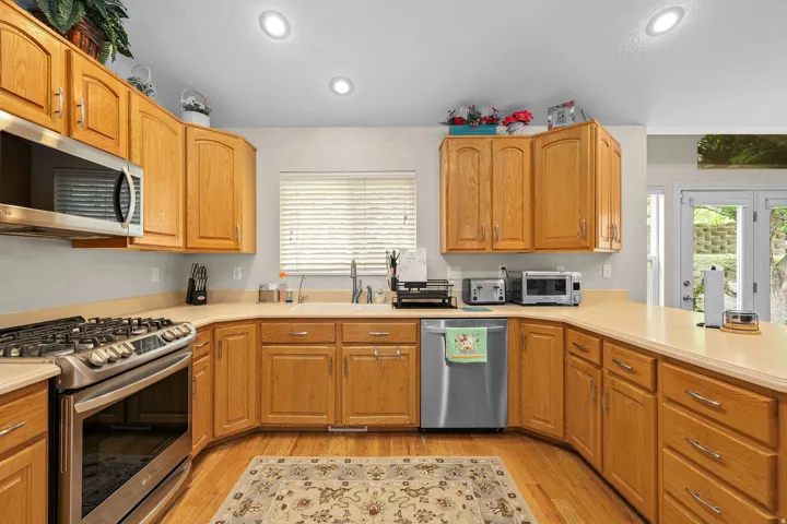 Kitchen featuring wood-finish cabinetry, light-toned countertops, and recessed lighting