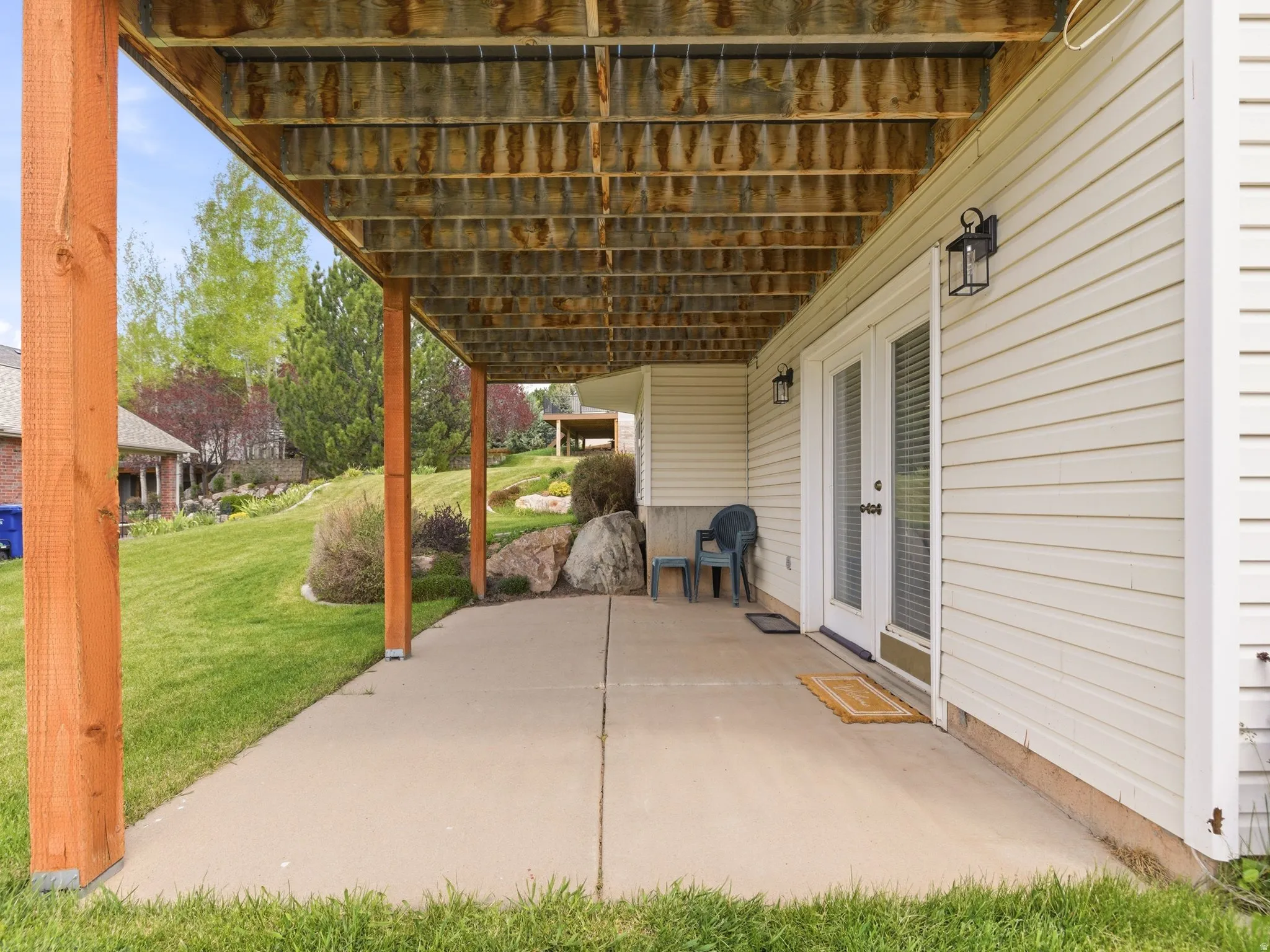 Covered concrete patio with wooden support columns
